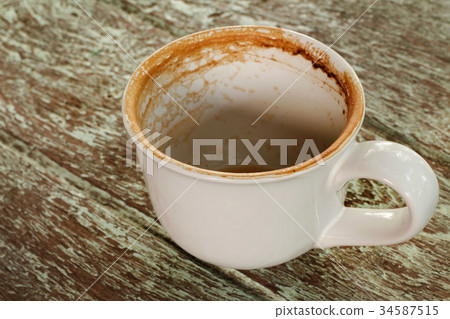 Dirty cup after drinking coffee on old wood table. 34587515