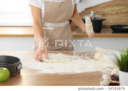 Female hands making dough for pizza or bread while Female hands making dough for pizza or bread while 34593674