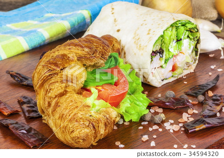 Croissant with cheese and tortilla wrap on table Croissant with cheese and tortilla wrap on table 34594320