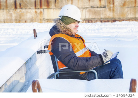 Disabled worker on wheelchair writing Disabled worker on wheelchair writing 34594324