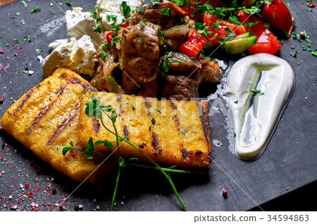 Grilled polenta, hominy with meat  34594863