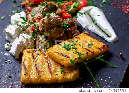 Grilled polenta, hominy with meat  34594864