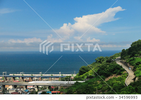 Shinkansen and limited express dancers run parallel to an iron bridge overlooking the summer clouds and Sagami Bay 34596993