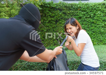 Thief stealing and jerking handbag from woman 34597571
