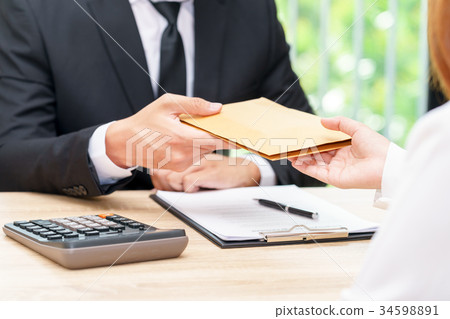 Businessman accepting money in envelope offered Businessman accepting money in envelope offered 34598891