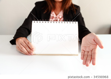 Businesswoman in black suit showing blank page 34598968
