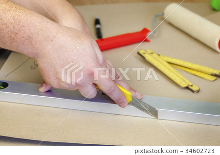 Builder using stationery knife Builder using stationery knife 34602723