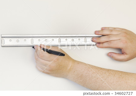 Worker keeping mounting plate on wall Worker keeping mounting plate on wall 34602727