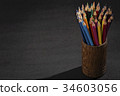 Bunch of color pencils in a dark room 34603056