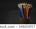Bunch of color pencils in a dark room 34603057