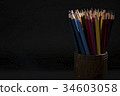 Bunch of color pencils in a dark room 34603058