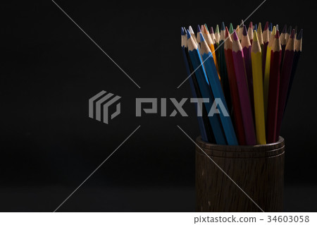 Bunch of color pencils in a dark room 34603058