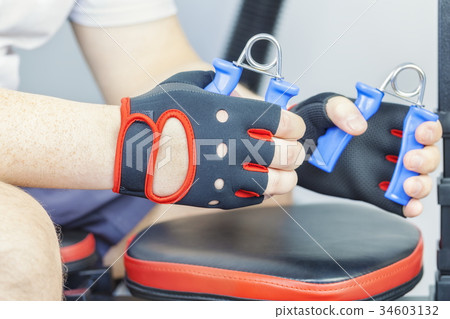 Man doing exercise with hand expander for wrist 34603132