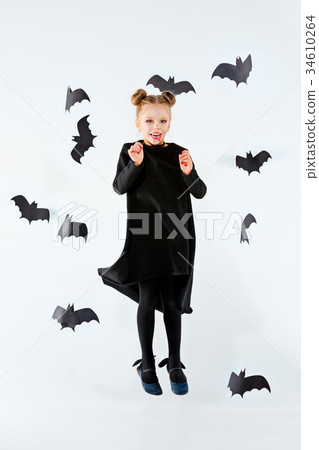 Little girl witch in black dress over magical 34610264