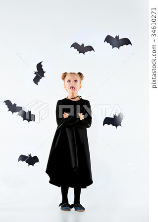 Little girl witch in black dress over magical 34610271