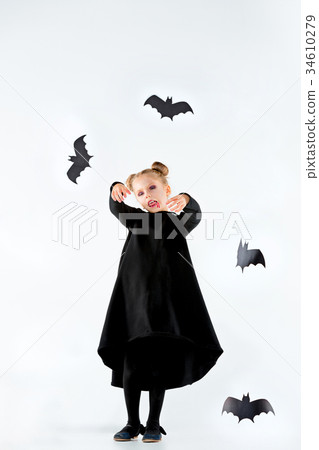 Little girl witch in black dress over magical 34610279