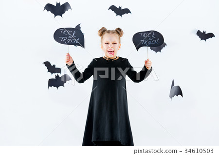 Little girl witch in black dress over magical 34610503