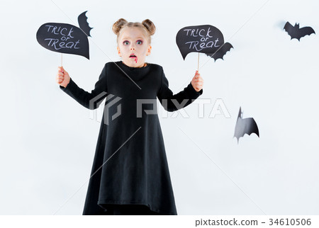 Little girl witch in black dress over magical Little girl witch in black dress over magical 34610506
