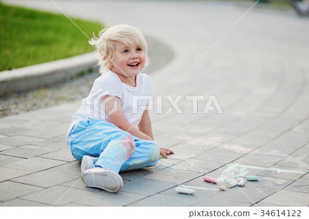Little boy drawing with chalks on asphalt Little boy drawing with chalks on asphalt 34614122