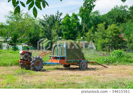 Old tractor with grass hay on trailer vehicle. Old tractor with grass hay on trailer vehicle. 34615561