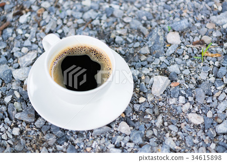 White cup of hot coffee on gray stone ground White cup of hot coffee on gray stone ground 34615898