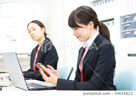 使用智能手機OL商人Salaryman個人計算機辦公室圖像企業圖像的女性僱員 使用智能手機OL商人Salaryman個人計算機辦公室圖像企業圖像的女性僱員 34616623