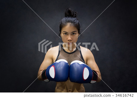 young Asian woman posing with boxing gloves young Asian woman posing with boxing gloves 34616742