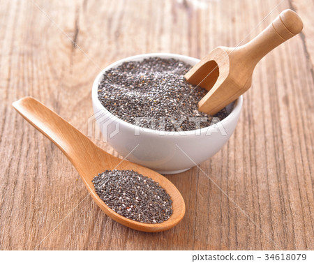 chia seeds in in a wooden spoon on a table chia seeds in in a wooden spoon on a table 34618079