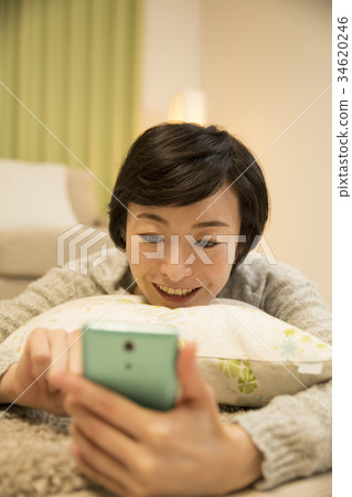 Allafour women operating a smartphone while lying asleep Allafour women operating a smartphone while lying asleep 34620246