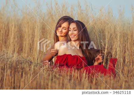 Women flirt in the field. Women flirt in the field. 34625118