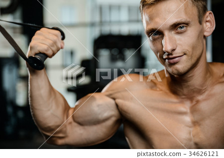 Handsome model young man training arms in gym 34626121
