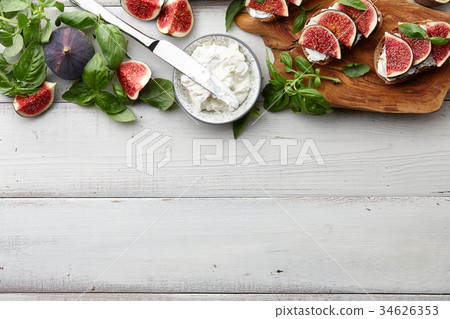 Fresh figs, basil and cream cheese bruschetta on white table 34626353