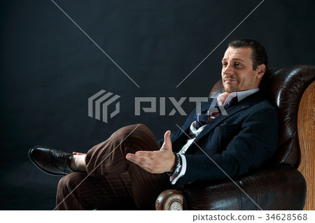 Businessman sitting on an armchair 34628568