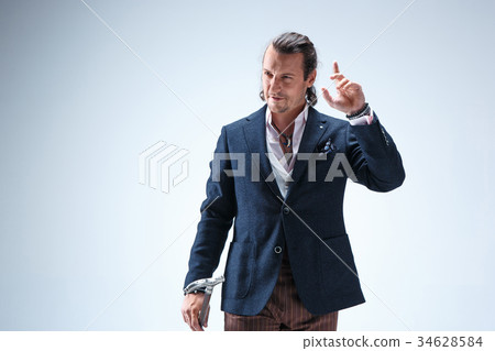 The mature barded man in a suit holding cane. 34628584