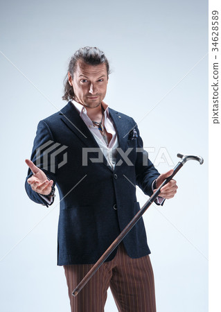 The mature barded man in a suit holding cane. The mature barded man in a suit holding cane. 34628589