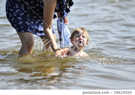 Mother teaches the kid to swim for the first time Mother teaches the kid to swim for the first time 34629504