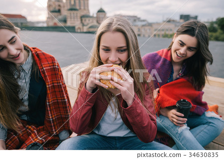 Young hot-eyed girl eats burger Young hot-eyed girl eats burger 34630835