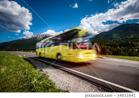 Yellow Public bus traveling on the road 34631641