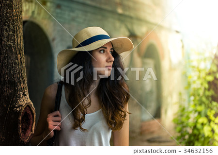 Girl with hat on summer day in the street. 34632156