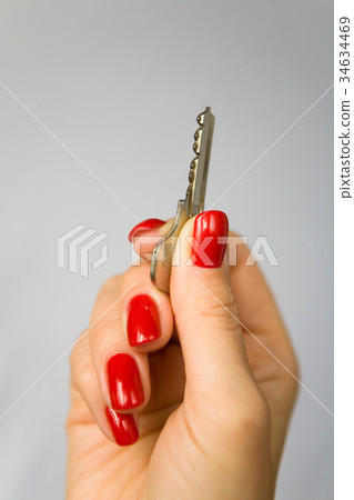 female fingers with red nails hold the key. 34634469