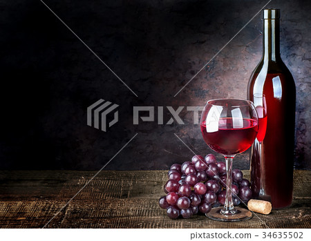 Glass of red wine with grapes and bottle Glass of red wine with grapes and bottle 34635502