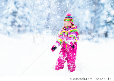 Child playing with snow in winter. Kids outdoors. Child playing with snow in winter. Kids outdoors. 34638012