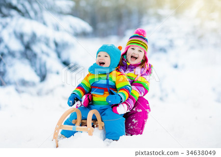 Kids on sleigh ride. Children sledding Winter snow 34638049