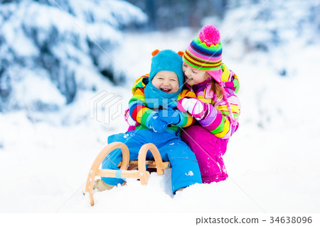 Kids on sleigh ride. Children sledding Winter snow 34638096