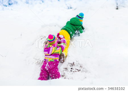 Kids playing in snow. Children in winter snowfall. 34638102