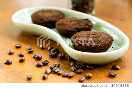 Coffee grounds in plates with coffee beans. 34644278