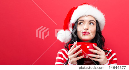 Woman with Santa hat drinking coffee 34644877