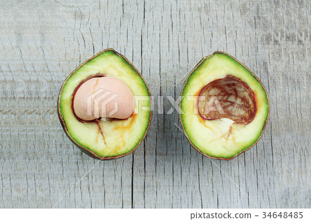 avocado cut on wooden floor. avocado cut on wooden floor. 34648485