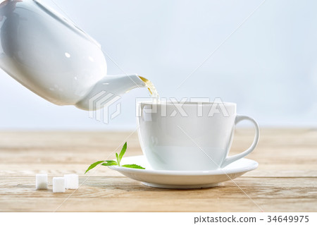cup with green tea and teapot on white wooden cup with green tea and teapot on white wooden 34649975