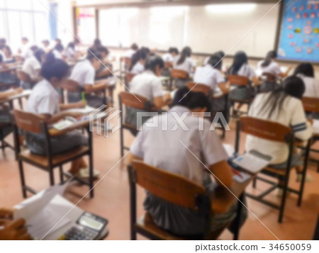 Blur students doing exam in classroom 34650059